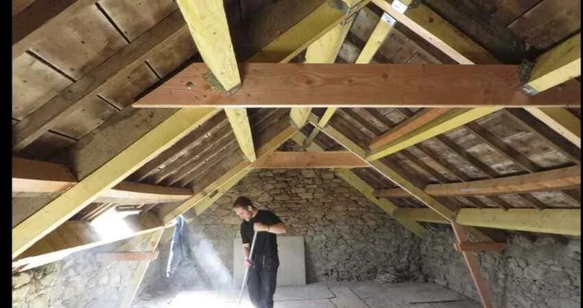 Charpente bois en grenier avec ouvrier au travail par Amédée Rénovation